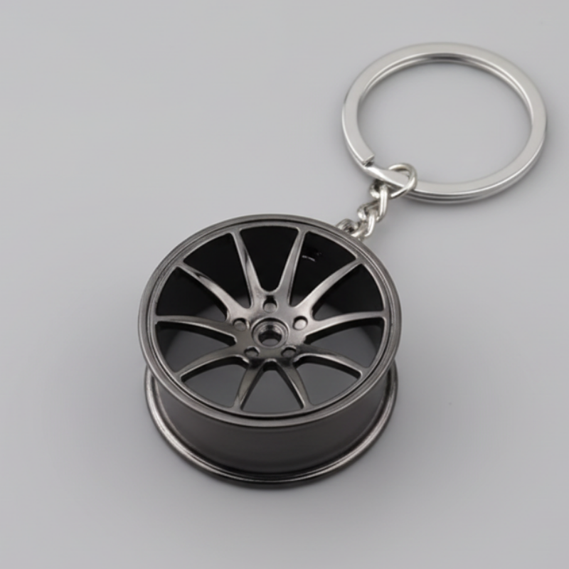 Metallic wheel-shaped keychain on a dark background