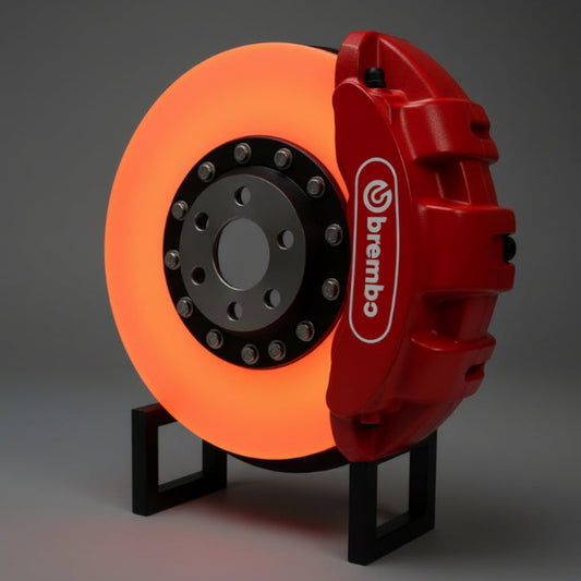 Red brake caliper with Brembo logo on a dark background