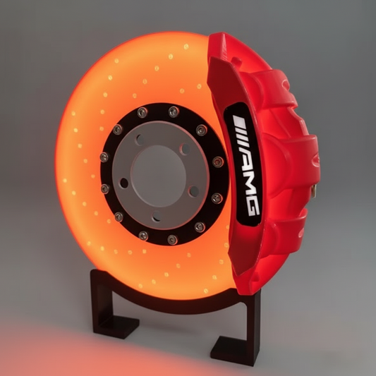 Orange glowing brake disc with red caliper on a stand against a dark background