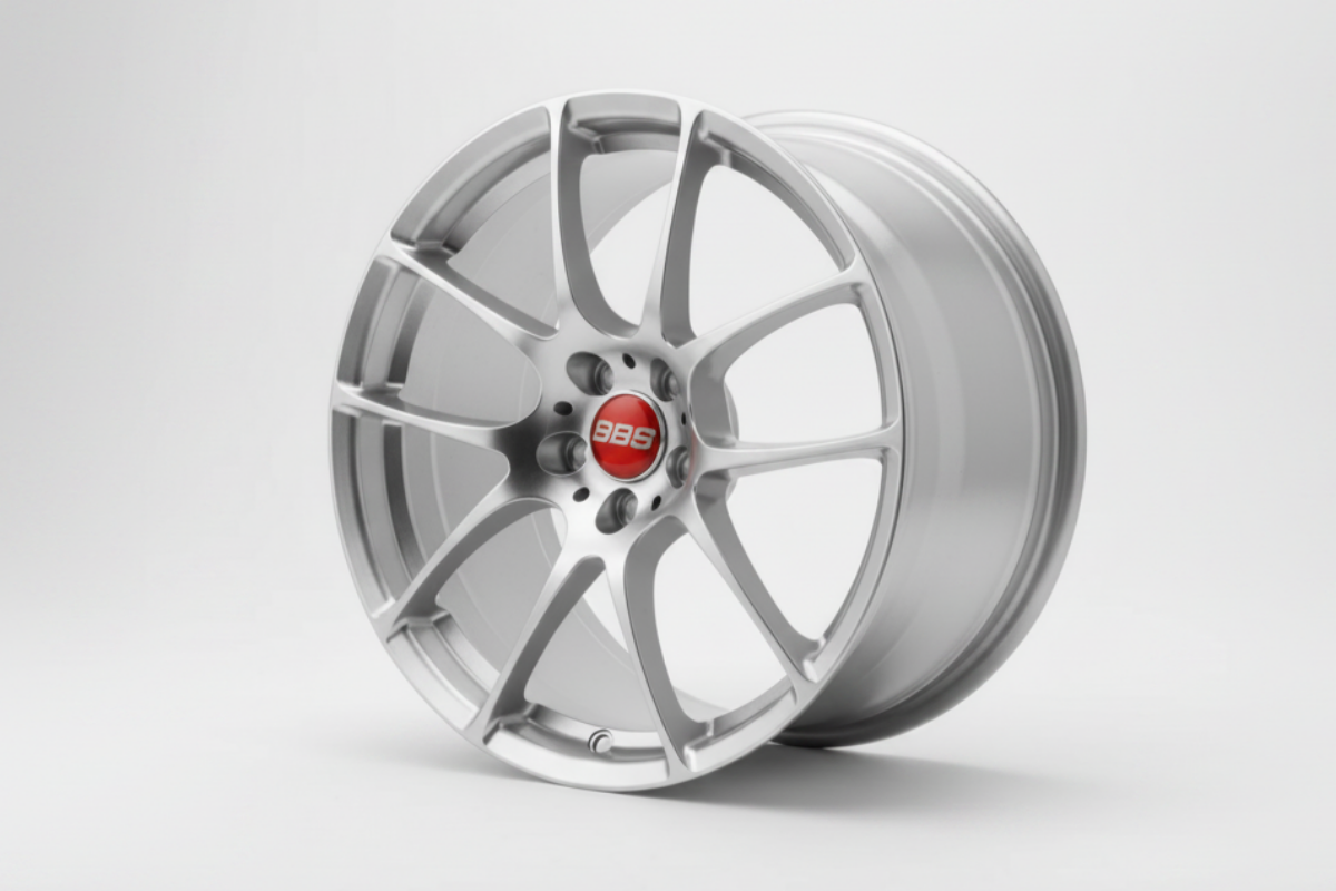 silver bbs rf wheel rim held by a hand against a green leafy background facing forward
