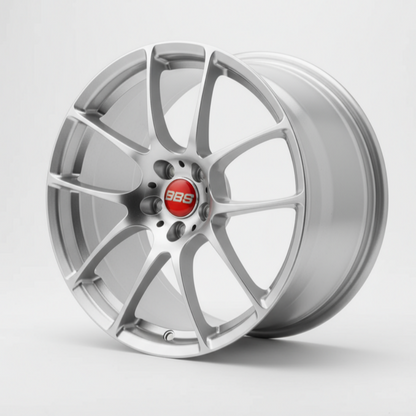 silver bbs rf wheel rim held by a hand against a green leafy background facing forward