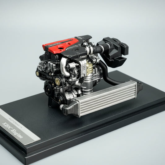 Model of a car engine on a black stand with a gray background
