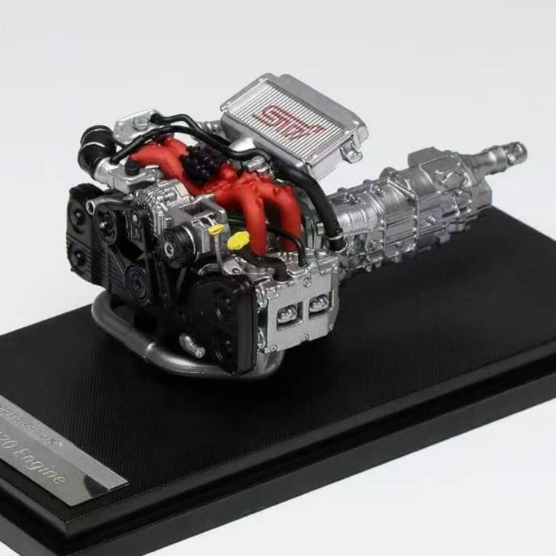 Model of a car engine on a black platform with a white background